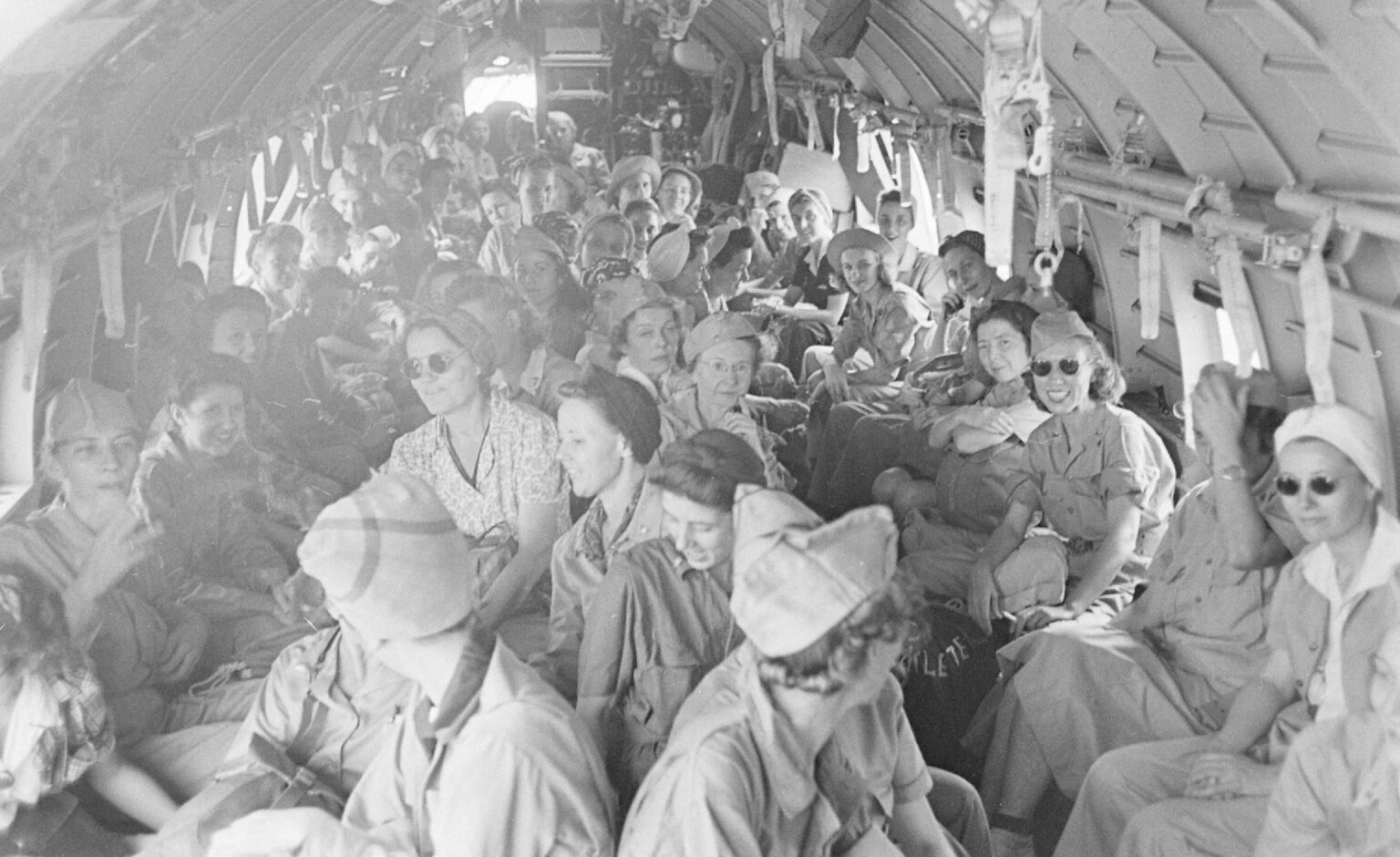 A cadre of Army nurses on a plane going home after 30 months in captivity in the Philippines during WWII. 